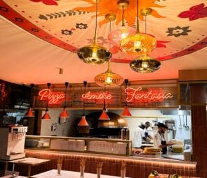 Cuisine du restaurant Antonio e Marco - Limas, plafond orange, tapisserie et néon pizza, amore e fantasia