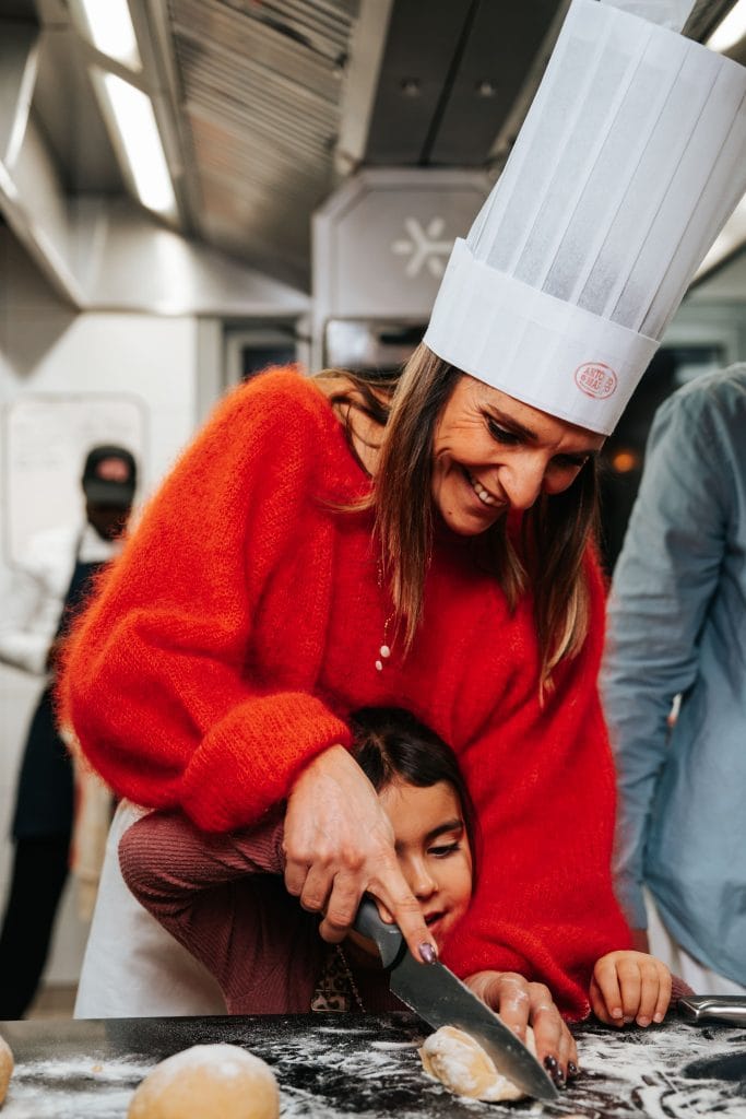 une femme et son enfant découpant une boule de pate fraîche au cours de cuisine à tassin-la-demi-lune
